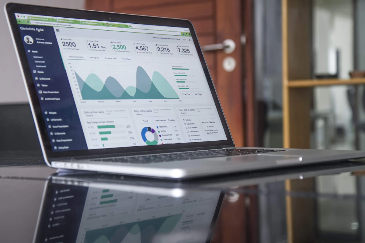 A high-resolution photograph of a laptop displaying business analytics and marketing charts.